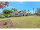 White house with tropical landscaping and a large grassy yard at 7003 River Club Blvd, Bradenton, FL 34202