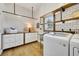 Bright laundry room with white subway tile, wooden shelves, and modern washer and dryer at 7003 River Club Blvd, Bradenton, FL 34202