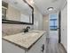 Bathroom with granite countertop, large mirror, and access to balcony at 7100 Sunshine Skyway S Ln # 706, St Petersburg, FL 33711