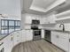 Modern white kitchen with stainless steel appliances and granite countertops at 7100 Sunshine Skyway S Ln # 706, St Petersburg, FL 33711