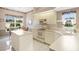 Bright kitchen with white cabinets, an island, and a view to the dining area at 7153 Drewrys Blf, Bradenton, FL 34203