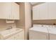 Bright laundry room with washer, dryer, and utility sink at 7153 Drewrys Blf, Bradenton, FL 34203