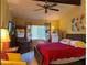 Main bedroom with a large red bed, ceiling fan, and yellow chair at 7312 Cloister Dr # 7312, Sarasota, FL 34231