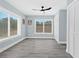 Bright bedroom with wood-look floors, ceiling fan, and ample closet space at 11216 Coralbean Dr, Lakewood Ranch, FL 34202
