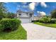 Two-story house with a white exterior, a brick driveway, and lush landscaping at 11216 Coralbean Dr, Lakewood Ranch, FL 34202