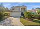 Two-story house with a light gray exterior, a brick driveway, and palm trees at 11216 Coralbean Dr, Lakewood Ranch, FL 34202