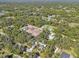 Aerial view showcasing a house nestled in a neighborhood with mature trees and other homes at 16102 Camas Ave, Port Charlotte, FL 33954