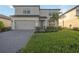 Two-story house with gray siding, a gray two-car garage, and a landscaped lawn at 16304 Hidden Oak Loop, Bradenton, FL 34211