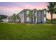 Two-story house with gray siding, lush lawn, and palm trees at 18307 White Fang Ct, Parrish, FL 34219