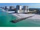 Aerial shot showing a beachfront building, a beach, blue water, and a rock barrier at 2110 Benjamin Franklin Dr # 108, Sarasota, FL 34236