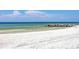 White sand beach with calm water and rocky shoreline at 2110 Benjamin Franklin Dr # 108, Sarasota, FL 34236