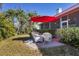 Peaceful patio with red umbrella and white wicker furniture at 2304 89Th Nw St, Bradenton, FL 34209