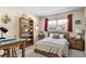 Cozy bedroom featuring a comfortable bed, wooden desk, and a bright window view at 2431 Golf Course Dr # 703, Sarasota, FL 34234