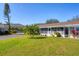 Well-maintained front yard with green grass, mature palm tree, and charming exterior at 2431 Golf Course Dr # 703, Sarasota, FL 34234