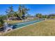 Well-maintained shuffleboard courts surrounded by green grass and mature trees at 2431 Golf Course Dr # 703, Sarasota, FL 34234