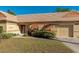 Tan house with orange shutters, a well-manicured lawn, and a paved driveway at 3607 57Th Avenue W Dr, Bradenton, FL 34210