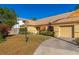 Tan house with orange shutters, a well-manicured lawn, and a paved driveway at 3607 57Th Avenue W Dr, Bradenton, FL 34210