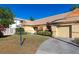 Tan house with orange shutters, a well-manicured lawn, and a paved driveway at 3607 57Th Avenue W Dr, Bradenton, FL 34210