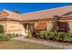 Tan house with orange shutters, a well-manicured lawn, and a paved walkway at 3607 57Th Avenue W Dr, Bradenton, FL 34210