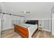 Spacious main bedroom with a wooden sleigh bed and barn door at 3607 57Th Avenue W Dr, Bradenton, FL 34210