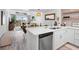Modern kitchen open to living area with white cabinets and stainless steel appliances at 4204 126Th W St # 506, Cortez, FL 34215