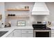 Bright kitchen featuring stainless steel appliances, floating shelves, and light gray subway tile at 4204 126Th W St # 506, Cortez, FL 34215