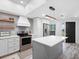 Bright kitchen with stainless steel appliances, center island, modern lighting, and gray backsplash at 4204 126Th W St # 506, Cortez, FL 34215