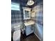 Charming powder room featuring blue plaid wallpaper, white wainscoting, and a classic vanity at 4707 Woodbrook Dr, Sarasota, FL 34243