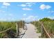 Sandy pathway lined with vegetation, leading to the beach at 5019 Commonwealth Dr, Sarasota, FL 34242
