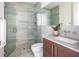 Modern bathroom with glass shower, gray tile, and wood vanity at 509 Golden Gate Pt # 3, Sarasota, FL 34236