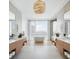 Spa-like bathroom with double vanities, a freestanding tub, and large windows at 509 Golden Gate Pt # 3, Sarasota, FL 34236