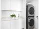 Bright laundry room with front-load washer and dryer and white cabinets at 509 Golden Gate Pt # 3, Sarasota, FL 34236