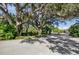 Gated community entrance with lush landscaping and large oak trees at 5209 Manorwood Dr # 3A, Sarasota, FL 34235