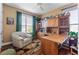 Home office with built-in wood shelving and a comfortable armchair at 5209 Manorwood Dr # 3A, Sarasota, FL 34235