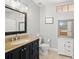 Bathroom featuring a toilet, vanity with granite counters, large mirror, and linen cabinet at 5601 Bentgrass Dr # 10-112, Sarasota, FL 34235