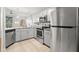Well-lit kitchen features stainless steel appliances, granite countertops, and hardwood floors at 5601 Bentgrass Dr # 10-112, Sarasota, FL 34235