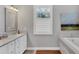 Elegant bathroom features soaking tub, double vanity, and hardwood floors at 5868 Meriwether Pl, Sarasota, FL 34232