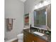 Small bathroom with dark vanity, framed mirror, and shower at 5868 Meriwether Pl, Sarasota, FL 34232