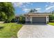 Single-story home with a tile roof, paver driveway, and landscaped lawn at 5868 Meriwether Pl, Sarasota, FL 34232