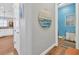 Hallway with coastal art and access to kitchen and laundry at 5868 Meriwether Pl, Sarasota, FL 34232