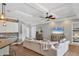Bright and airy living room with hardwood floors and a cozy sectional at 5868 Meriwether Pl, Sarasota, FL 34232
