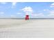 Scenic beach view with a lifeguard stand under a bright blue sky at 6451 Elmwood Ave # H, Sarasota, FL 34231