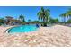 Large freeform pool with plenty of lounge chairs and umbrellas at 7015 River Hammock Dr # 203, Bradenton, FL 34212