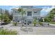 Two story home with gray siding, metal roof, and landscaped yard at 7418 Westmoreland Dr, Sarasota, FL 34243