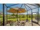 Enjoy this screened patio with seating and a tranquil backyard view at 7525 Alumni Trl, Sarasota, FL 34243