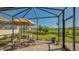 Relaxing screened patio with seating area, umbrella, and view of backyard at 7525 Alumni Trl, Sarasota, FL 34243