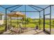 Relaxing screened porch with patio furniture and view of the backyard at 7525 Alumni Trl, Sarasota, FL 34243