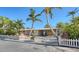 Single story home with palm trees and white picket fence at 834 Jungle Queen Way, Longboat Key, FL 34228
