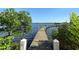 Wooden walkway leads to a private dock with calm water and lush greenery at 8767 Midnight Pass Rd # 203F, Sarasota, FL 34242