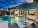 Luxury pool and spa with a covered patio and lounge chairs at 9224 Starry Night Ave, Sarasota, FL 34241